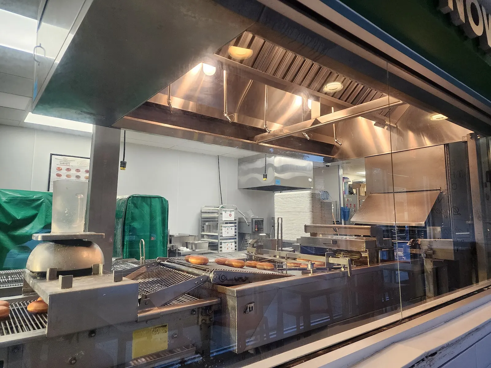 Doughnuts on the production line behind the window of a Krispy Kreme shop. The photo was taken in Destin, Florida, not at the St. Petersburg shop.