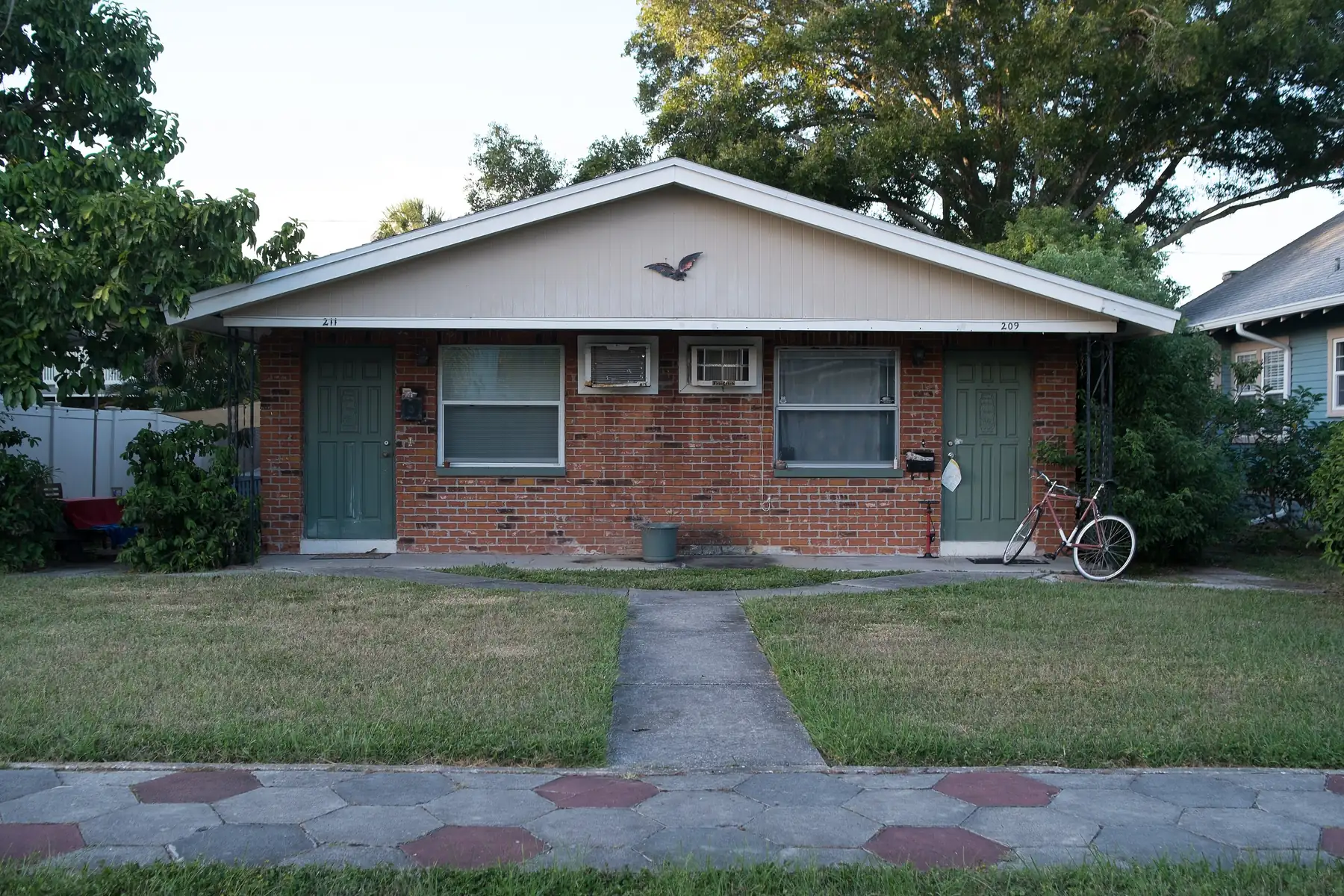 A brick duplex behind a hexagon-block sidewalk in Historic Old Northeast, St. Petersburg.