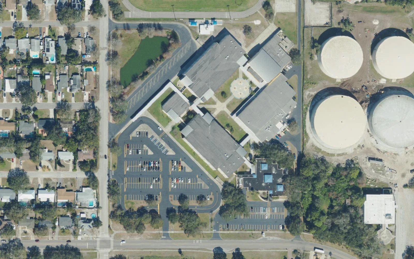 Azalea Middle School's campus on 22nd Avenue North in St. Petersburg seen from the air, beside four large round tanks on the neighboring property.