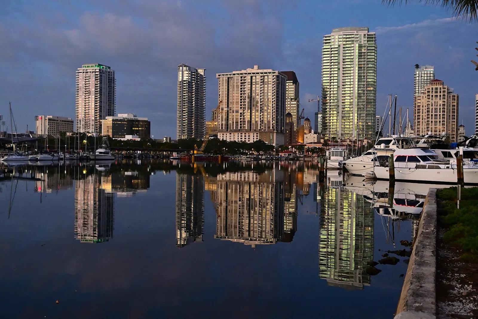 Downtown St. Petersburg towers reflected in the water of the downtown marina at sunrise.