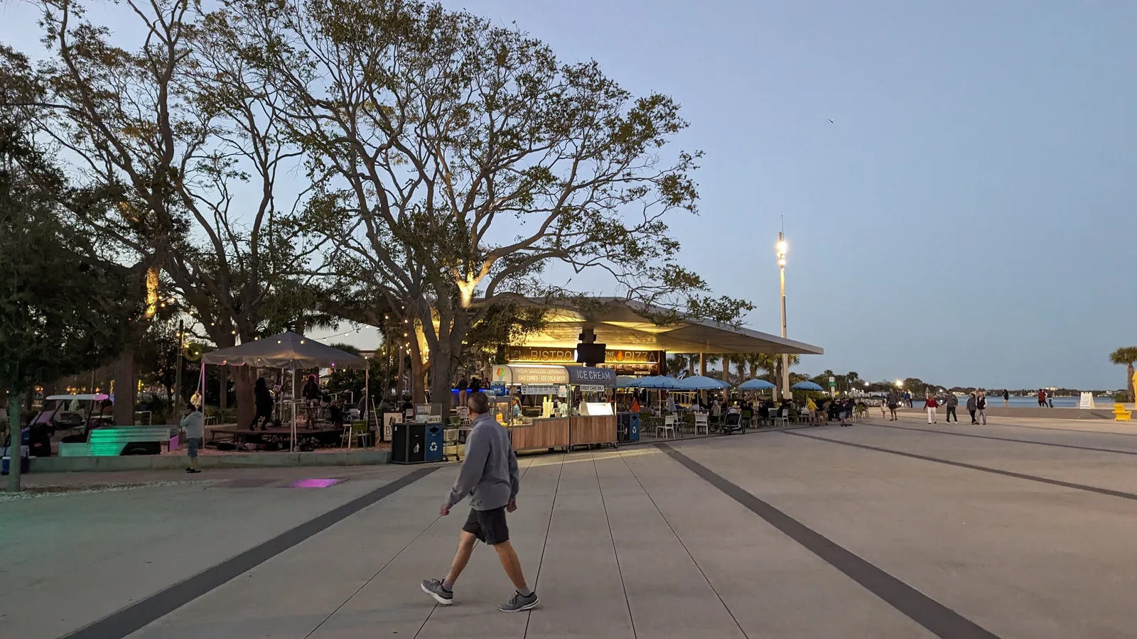 Visitors walk past the Spa Beach Bistro at Spa Beach Park on the St. Pete Pier at dusk.