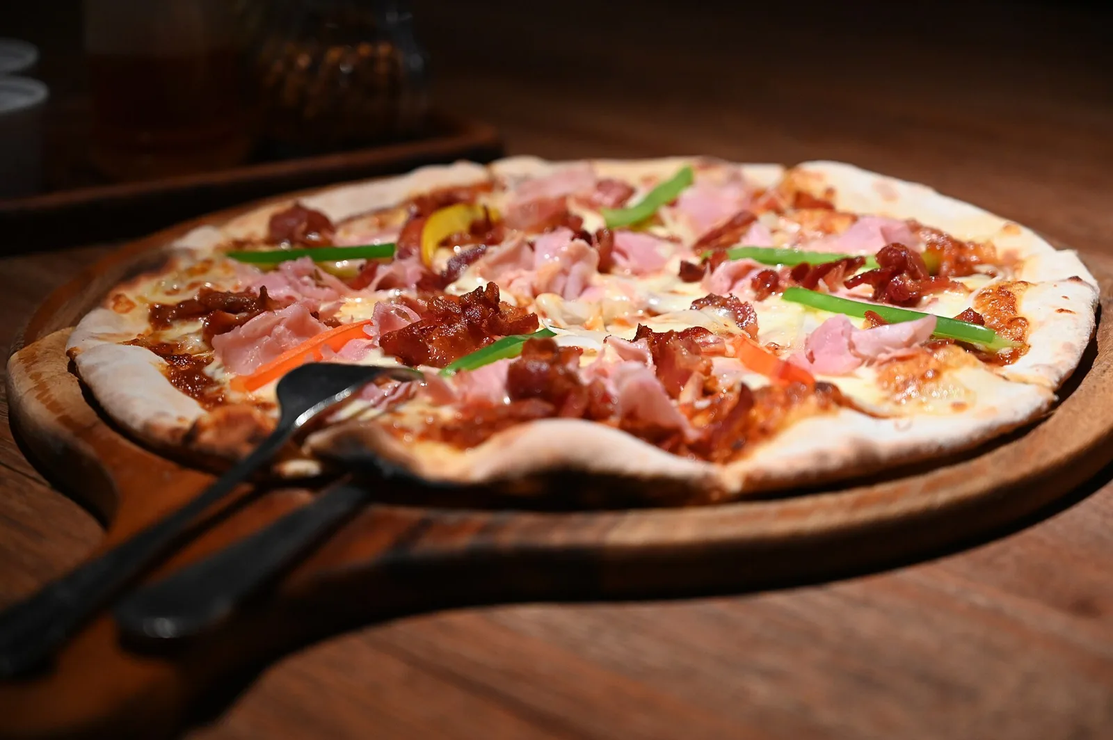 A wood-fired pizza on a serving board. The photo is a stock food picture, not one taken at a place on this list.